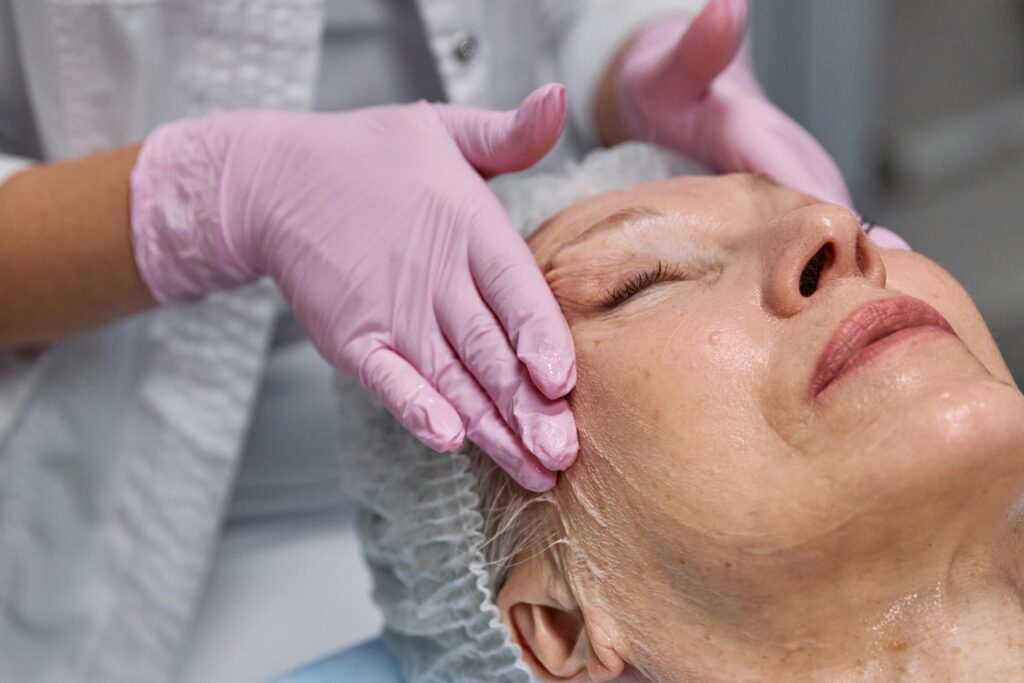 Serene facial massage for mature woman at spa. Tranquil spa experience.
