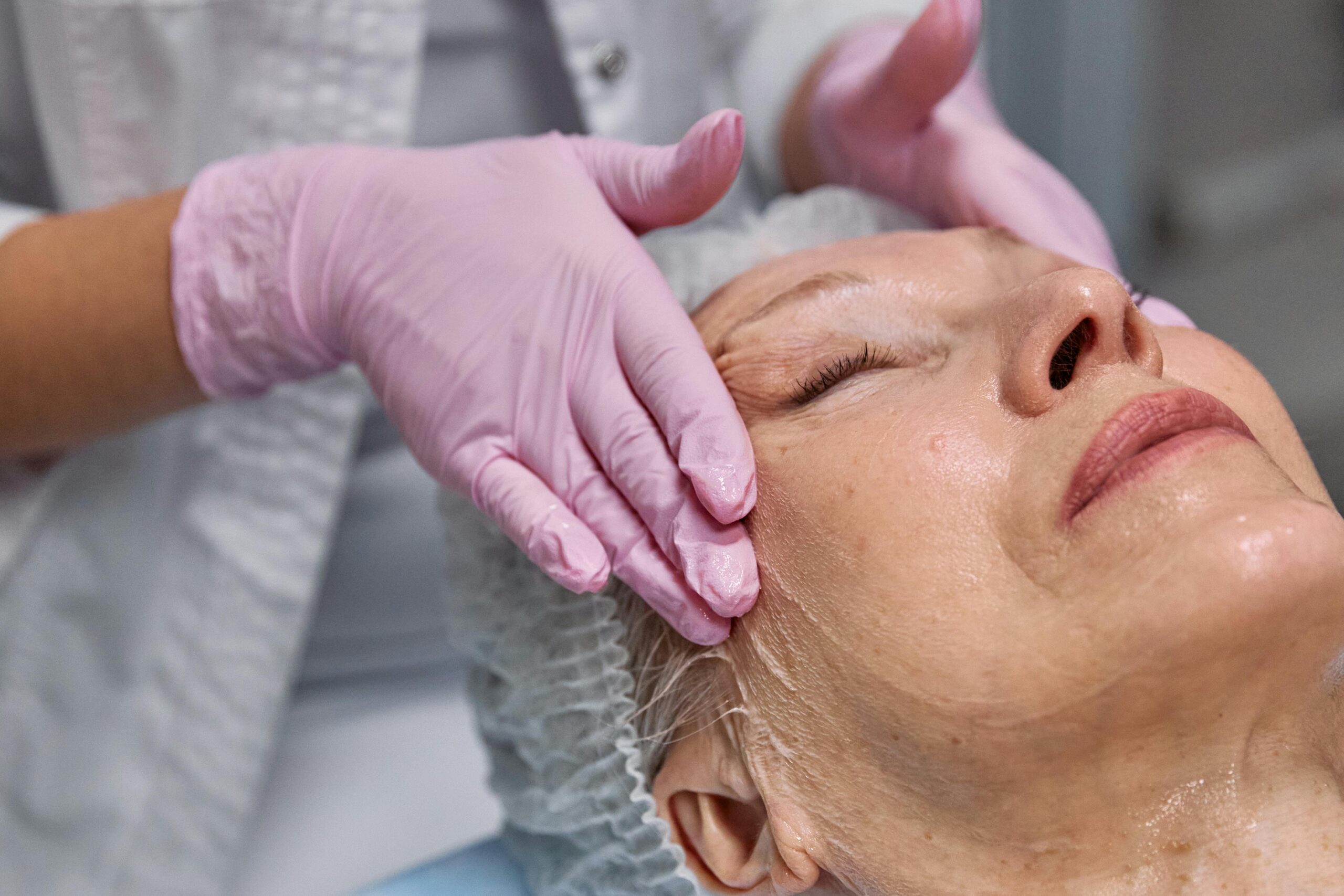 Serene facial massage for mature woman at spa. Tranquil spa experience.